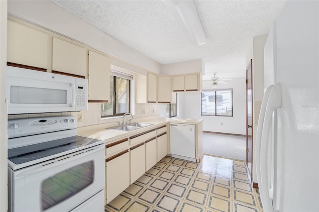 kitchen with sink, white appliances, a textured ceiling, ceiling fan, and cream cabinets