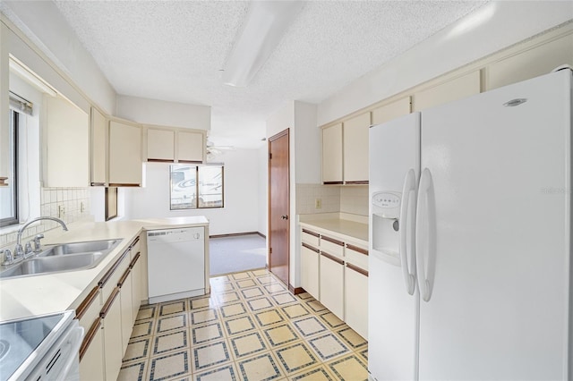 kitchen with sink, white appliances, backsplash, a textured ceiling, and kitchen peninsula