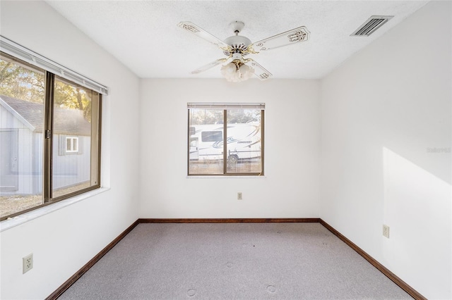 spare room featuring a textured ceiling, ceiling fan, and carpet flooring