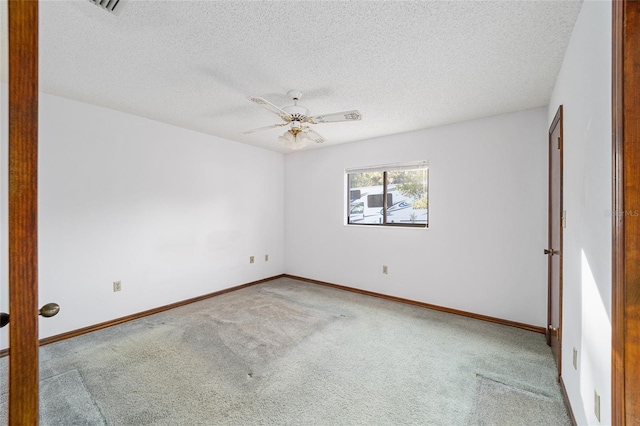 empty room with ceiling fan, carpet, and a textured ceiling