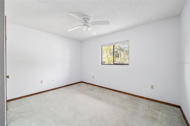 carpeted empty room with ceiling fan and a textured ceiling