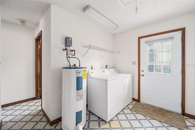 laundry room with electric water heater, a textured ceiling, and independent washer and dryer