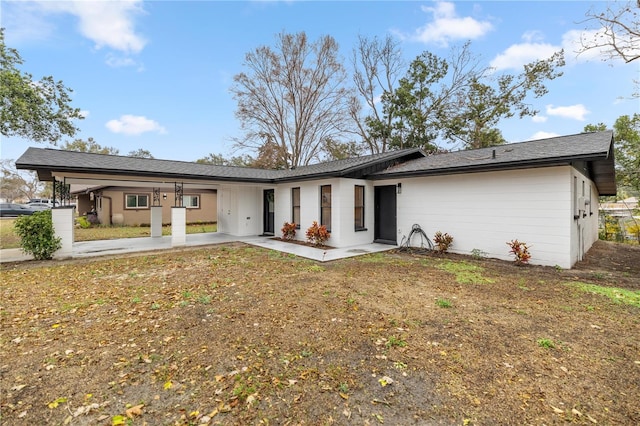 rear view of house featuring a patio area and a lawn