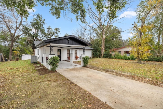 bungalow featuring central AC, board and batten siding, and a front yard