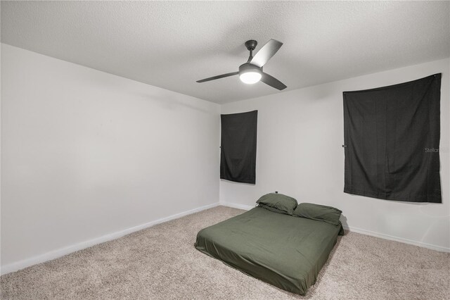 bedroom featuring carpet floors, baseboards, and a textured ceiling