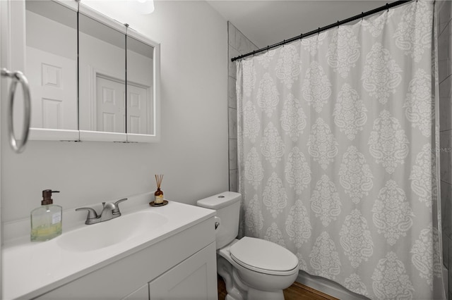 bathroom featuring curtained shower, vanity, and toilet