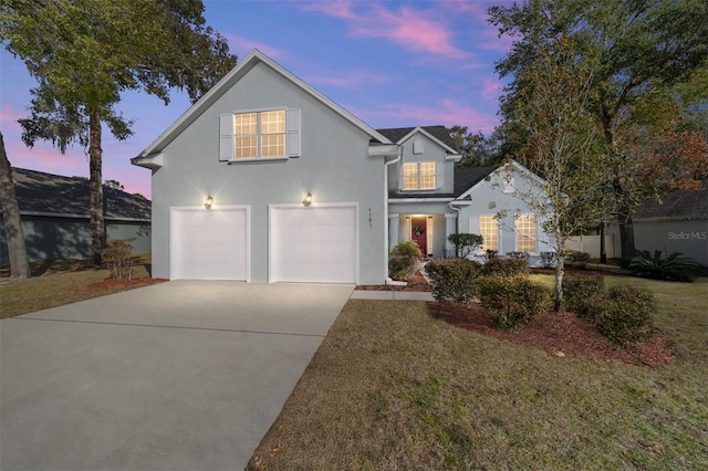 front facade with a garage and a lawn