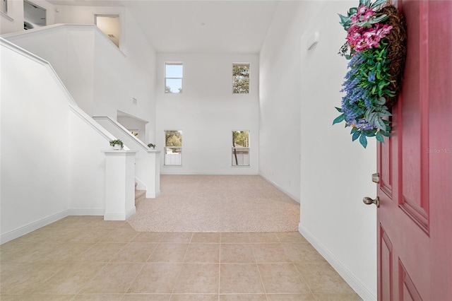 carpeted foyer featuring a high ceiling