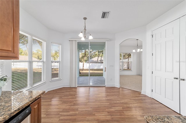 unfurnished dining area featuring dark hardwood / wood-style flooring and a chandelier