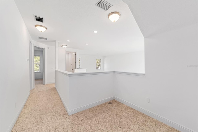 interior space with light carpet and kitchen peninsula