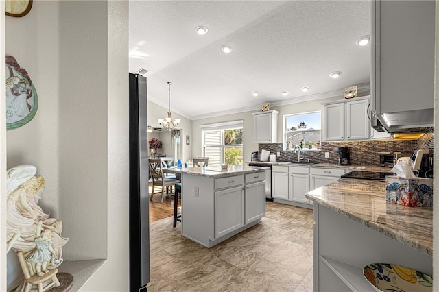 kitchen with light stone countertops, a kitchen island, a breakfast bar area, and stainless steel dishwasher