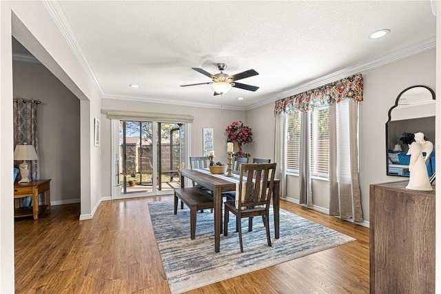 dining space with crown molding, plenty of natural light, hardwood / wood-style floors, and a textured ceiling