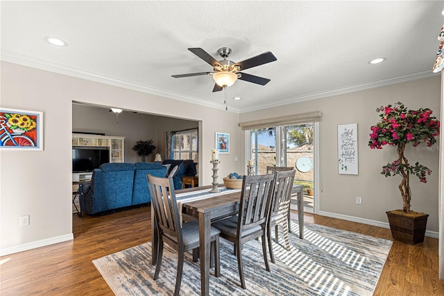 dining area with crown molding, ceiling fan, dark hardwood / wood-style flooring, and a textured ceiling