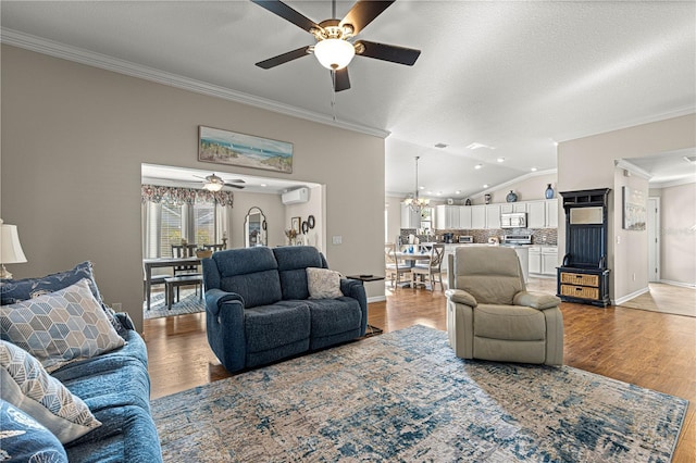 living room with lofted ceiling, wood-type flooring, a textured ceiling, ornamental molding, and ceiling fan with notable chandelier