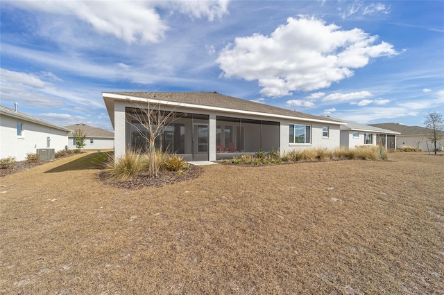 back of house featuring a sunroom, cooling unit, and a lawn