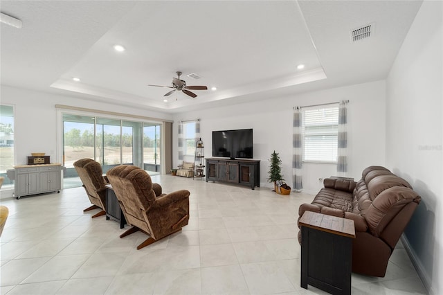 tiled living room featuring a tray ceiling and ceiling fan