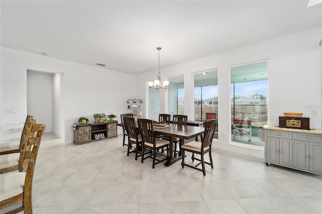 dining area with an inviting chandelier and a textured ceiling