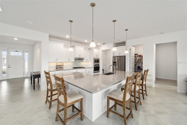 kitchen featuring stainless steel appliances, white cabinetry, and a spacious island