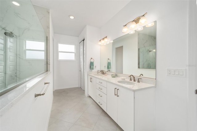 bathroom featuring tiled shower, vanity, and tile patterned flooring