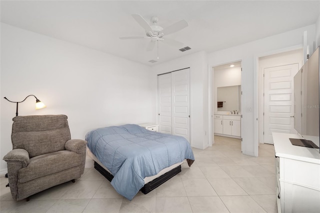 bedroom featuring light tile patterned floors, connected bathroom, ceiling fan, and a closet