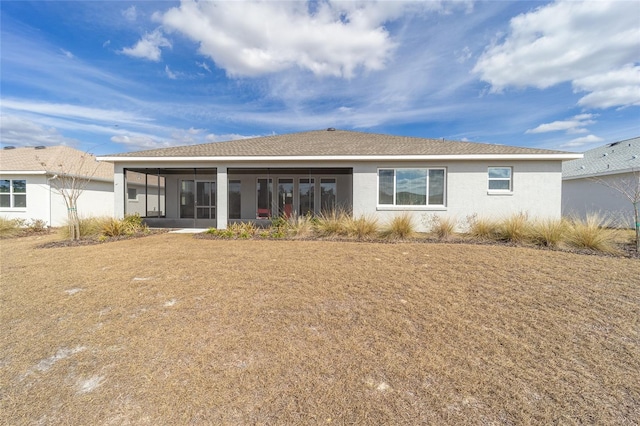 rear view of property featuring a lawn and a sunroom