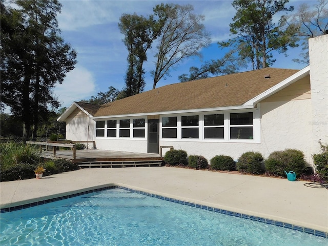 back of property with a pool side deck