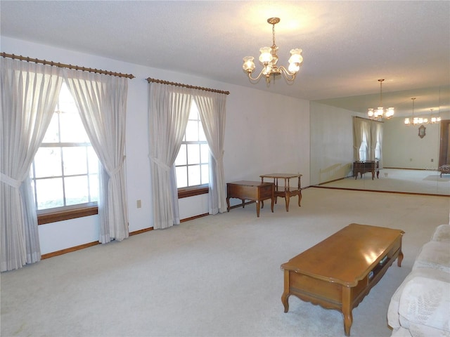 carpeted living room featuring a chandelier