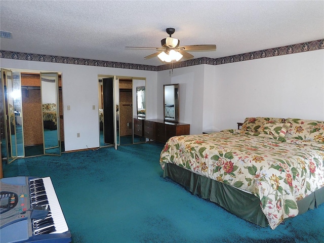 bedroom featuring multiple closets, carpet flooring, a textured ceiling, and ceiling fan