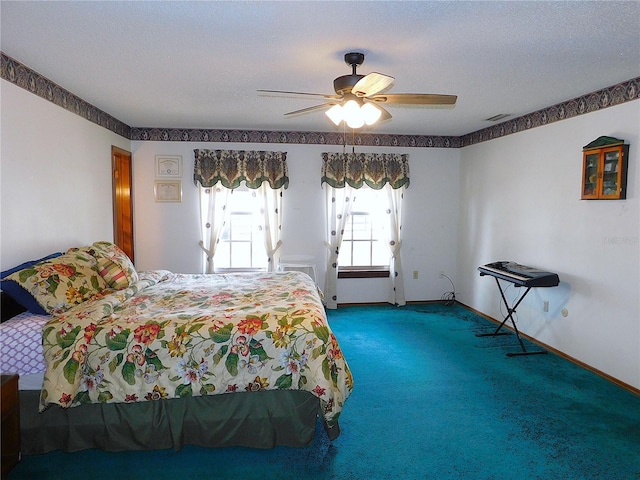 bedroom with ceiling fan, carpet floors, and a textured ceiling