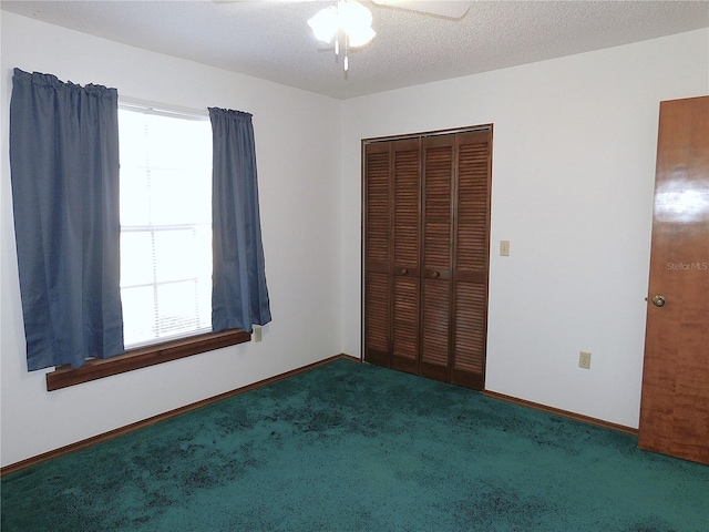 unfurnished bedroom with ceiling fan, carpet flooring, a closet, and a textured ceiling