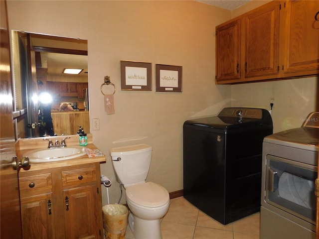 bathroom featuring vanity, washer and clothes dryer, tile patterned floors, and toilet