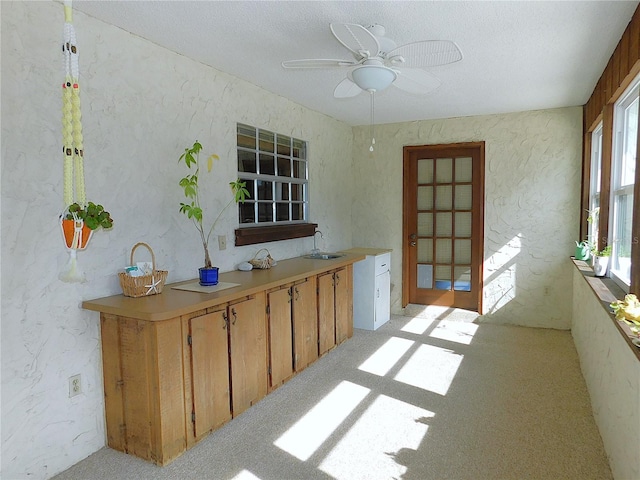 interior space with sink, light colored carpet, and ceiling fan