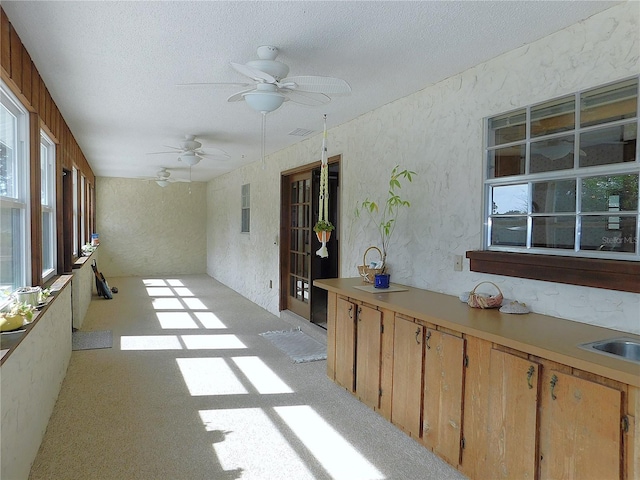 unfurnished sunroom featuring ceiling fan