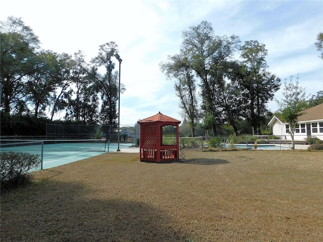 exterior space featuring tennis court and a lawn