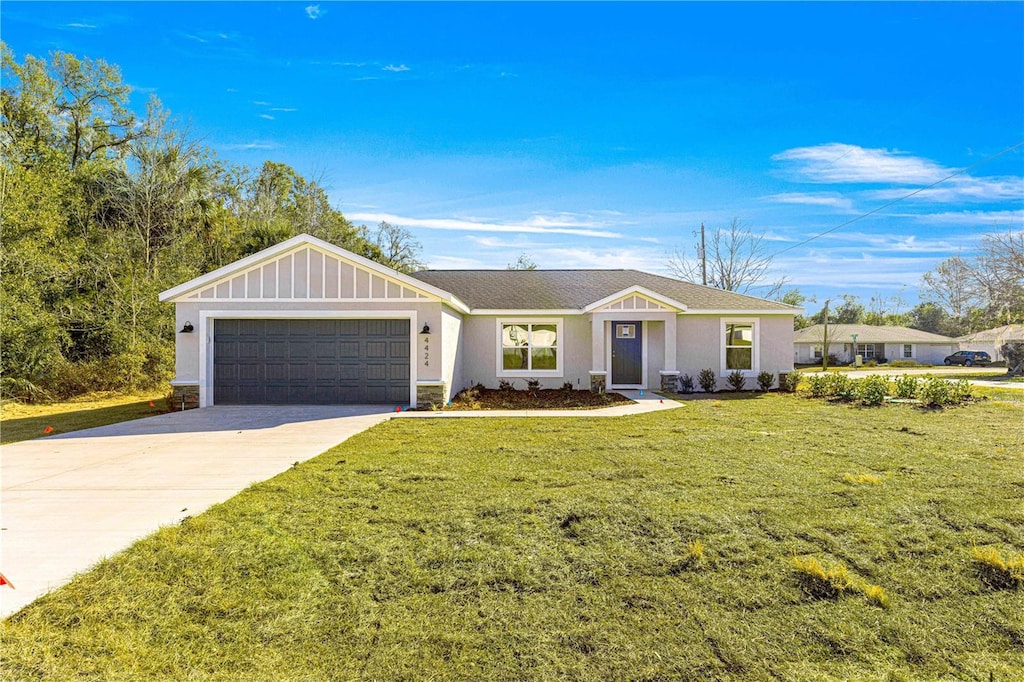 single story home with a garage and a front lawn