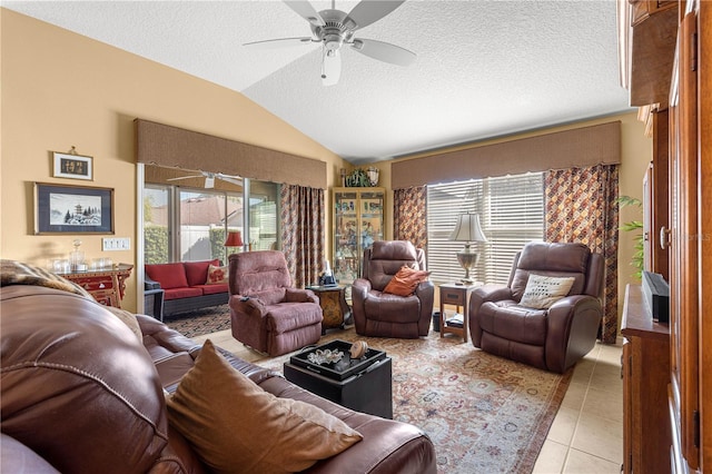 tiled living room featuring vaulted ceiling, a textured ceiling, and ceiling fan