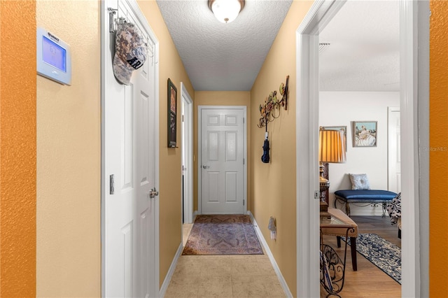 hallway with a textured ceiling