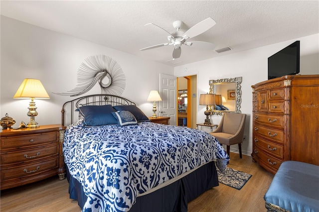 bedroom with ceiling fan, a textured ceiling, and light hardwood / wood-style flooring