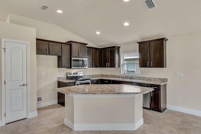 kitchen featuring dark brown cabinets, stainless steel appliances, vaulted ceiling, a kitchen island, and sink