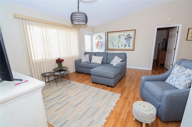 living room featuring vaulted ceiling and light wood-type flooring