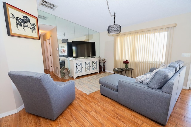 living room featuring vaulted ceiling and hardwood / wood-style floors