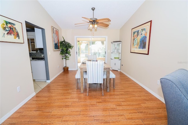 dining area featuring vaulted ceiling, light hardwood / wood-style floors, and ceiling fan