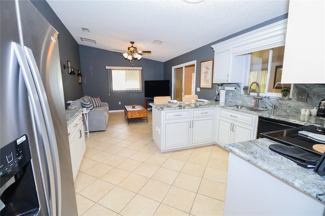 kitchen featuring stainless steel fridge with ice dispenser, white cabinetry, lofted ceiling, sink, and kitchen peninsula