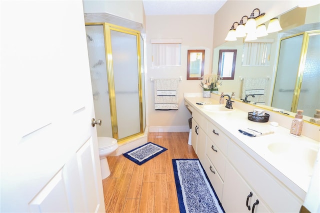 bathroom featuring vanity, a shower with shower door, toilet, and wood-type flooring