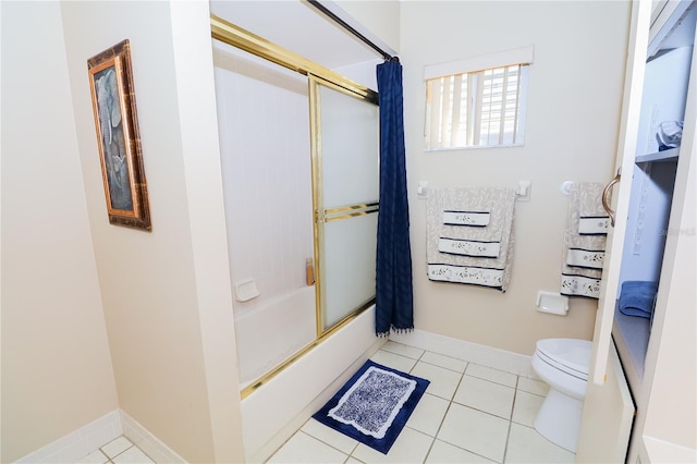 bathroom featuring shower / bath combination with glass door, tile patterned floors, and toilet