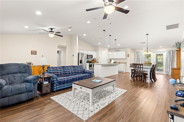 living room featuring wood-type flooring, ceiling fan, and vaulted ceiling