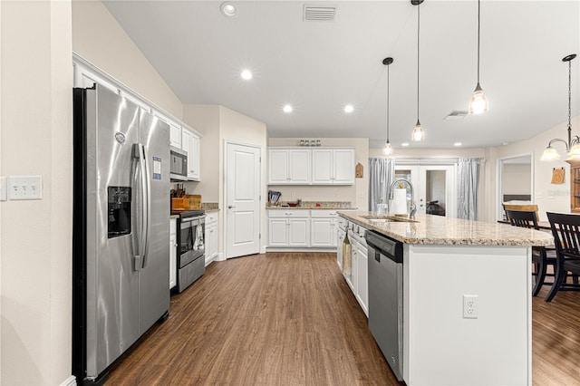 kitchen with appliances with stainless steel finishes, sink, a kitchen island with sink, and hanging light fixtures