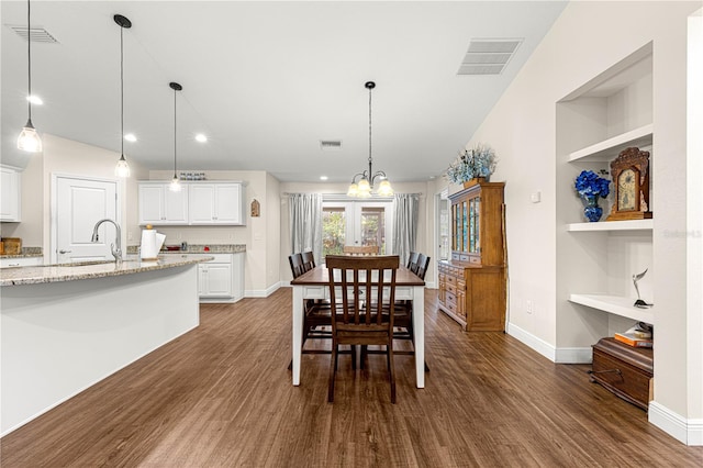 dining space featuring sink, built in shelves, and dark hardwood / wood-style floors