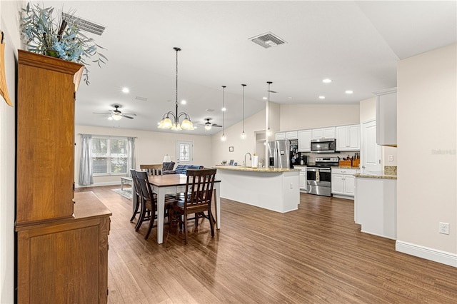 dining area with lofted ceiling, sink, ceiling fan with notable chandelier, and light hardwood / wood-style floors