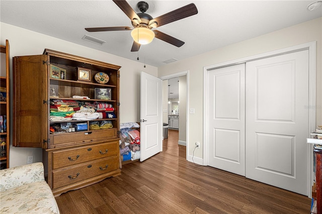 bedroom featuring dark hardwood / wood-style floors, a closet, and ceiling fan